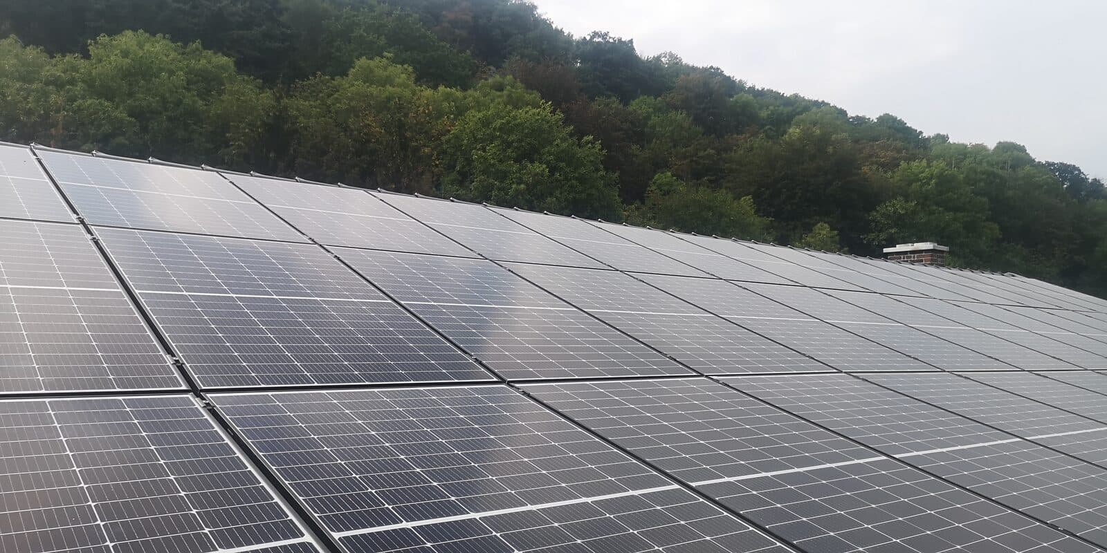 Solaranlage · Mehrfamilienhaus — Großflächige Dachanlage am Hang